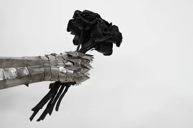 A plate gauntlet holding a bouquet of forged roses